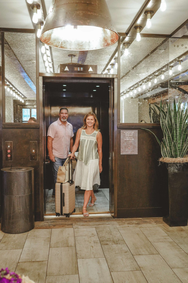 A couple stands in an elevator doorway